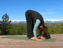 Standing Forward Bend yoga pose with the Sangre de Cristo Mountain view, Colorado.