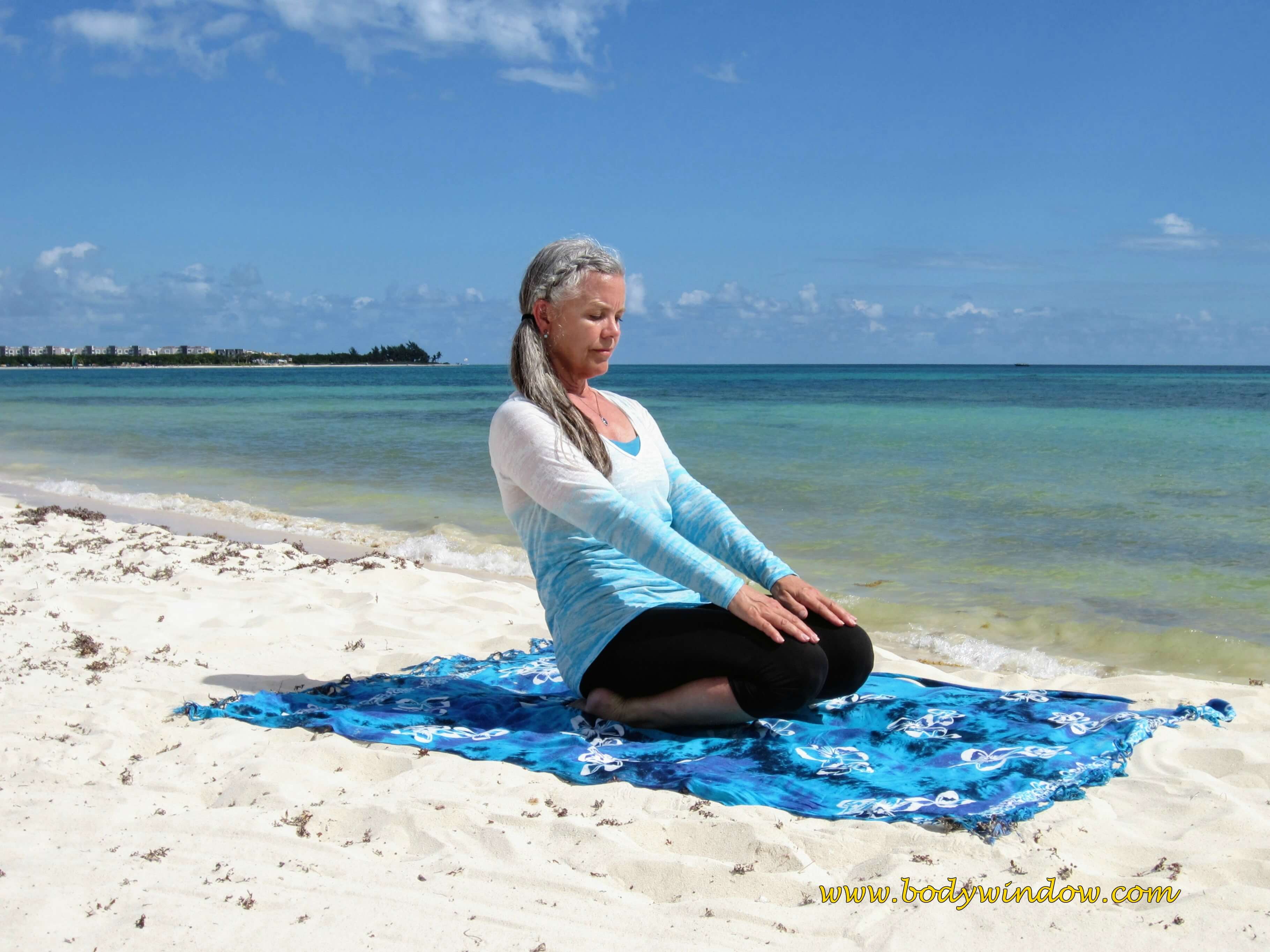 Full Ankle Stretch Pose, on a beach in Playa del Carmen, Mexico.