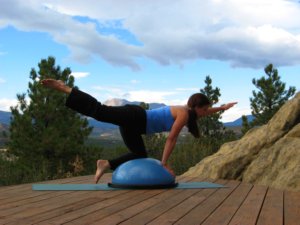 Bosu ball, kneeling with one arm raised and opposite leg raised. 