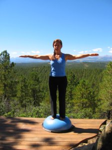 Standing Balance on Bosu Ball with arms out in Cross position. 