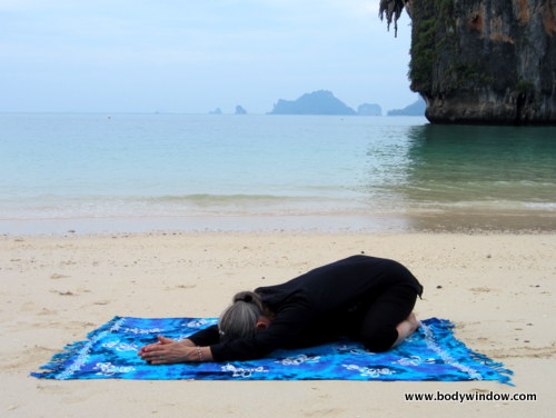 Photo of Elle Bieling doing Wide-Knee Child's Pose in Yin Yoga on Pranang Beach, Railay, Thailand